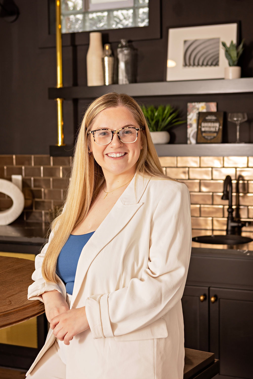 Professional branding portrait of a woman in a white blazer in a modern interior